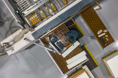 Skilled machine operator processing and sizing a plastic sheet utilizing high tech equipment