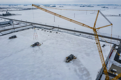 Drone perspective of a large air-conditioner unit being installed in winter on the roof of the Ferrera distribution facility
