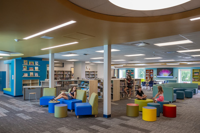 Young kids reading and hanging out at a colorful middle school library 