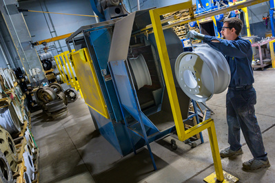 Painting operator loading the mechanical paint line inside a truck maintenance facility