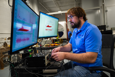 Technician testing and analyzing the electro current conductivity of an industrial fan part