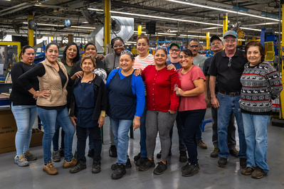 Group of production line operators and supervisor in an Airflow Systems facility