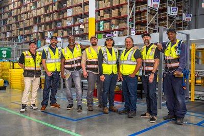 Service team members posing for a group photo at a very large distribution facility