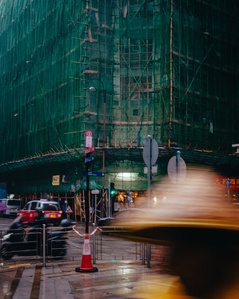 A pedestrian avoids the rain in a traditional conical straw hat in Kowloon, Hong Kong.