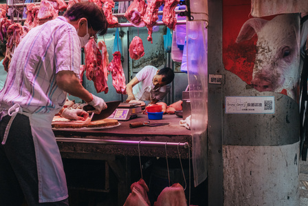 Two butchers prepare meat at a wet market in Kowloon, Hong Kong.