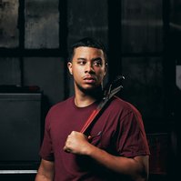 Commercial headshot of employee standing with tool.
