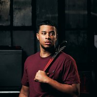 Commercial headshot of employee standing with tool.