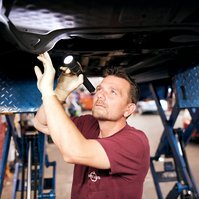Portrait of employee working on car.