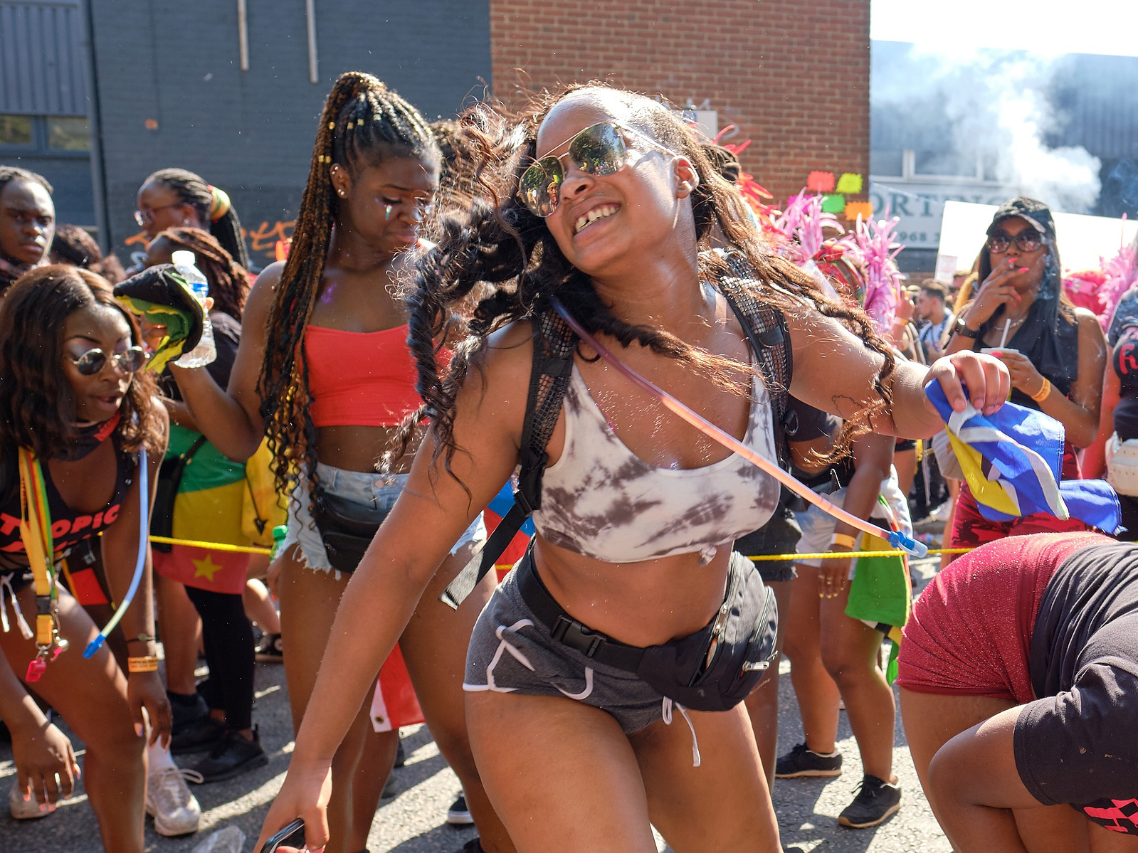 a crowd of stylish young women dance in the dense streets of notting hill carnival