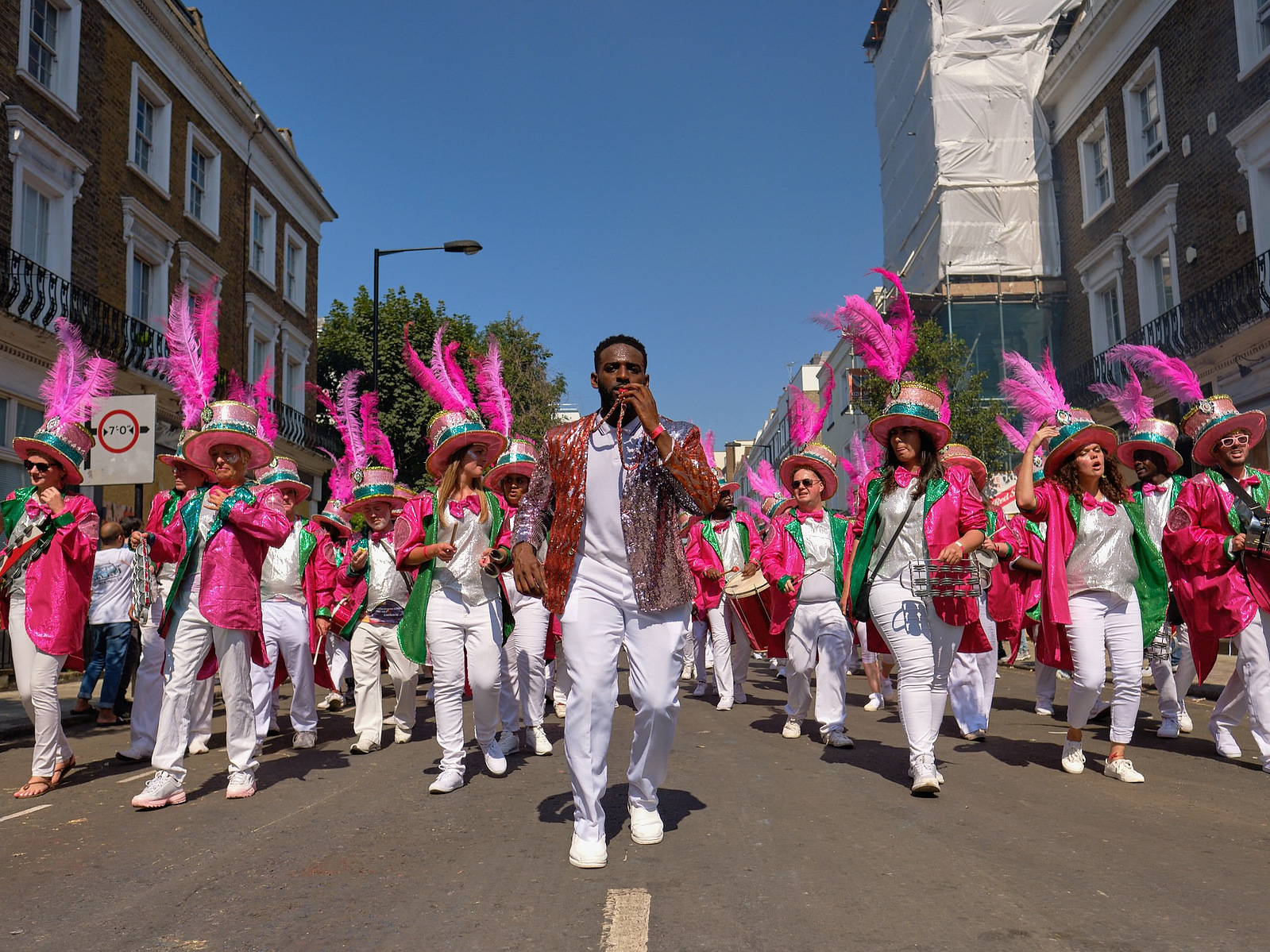 a man leads the paraiso school of samba band through the hot streets of notting hill carnival
