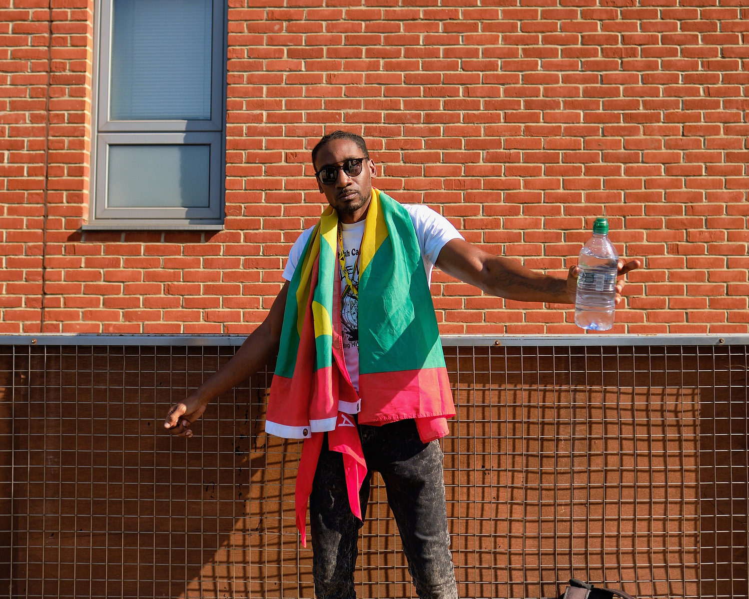 a stylish man in a flag poses for a street portrait