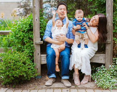 family of 4 sits on park bench during family photo session