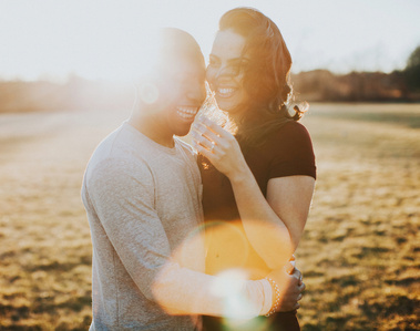 a man and woman posing in a field