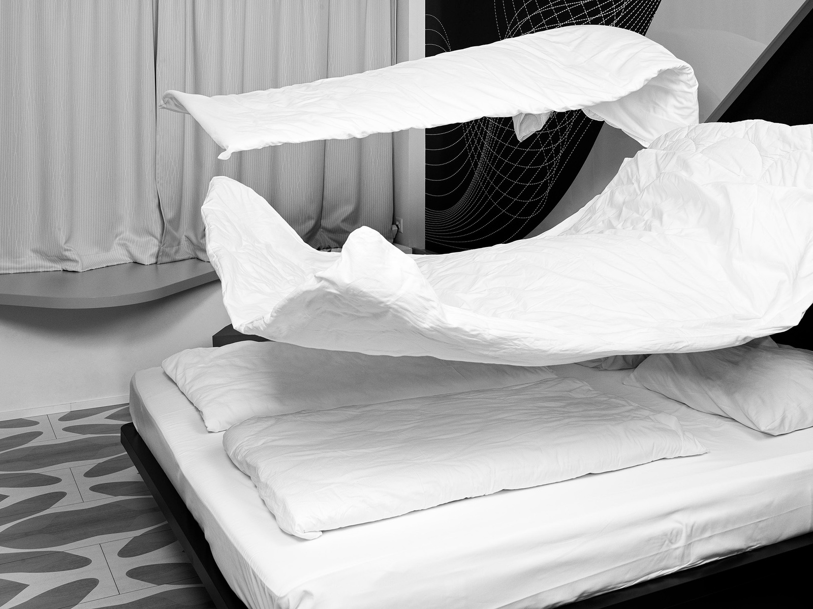 Black and white image of hotel bed with dramatically floating sheets and pillows
Camera Hasselblad Flexbody 50CFV ii "Fabric of Dreams" - The poetic dance of linens in the realm of temporary repose