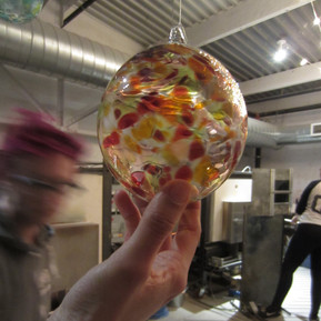 A hand holding a glass ornament.