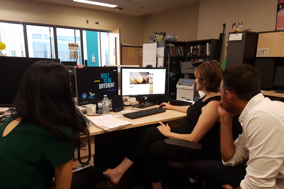 Three people looking at a computer screen.