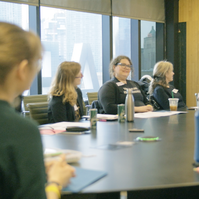 A group of people sitting a round table.