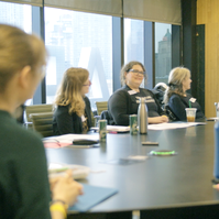 A group of people sitting a round table.