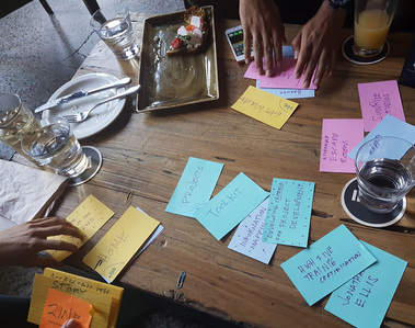 Hands arranging title cards on a table with water and food.