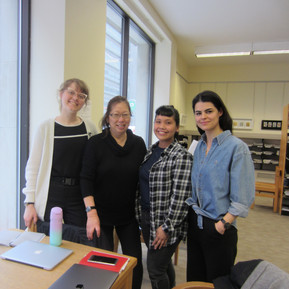 Four people smiling in a library.
