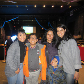 Three adults and two children smiling in a group picture. 
