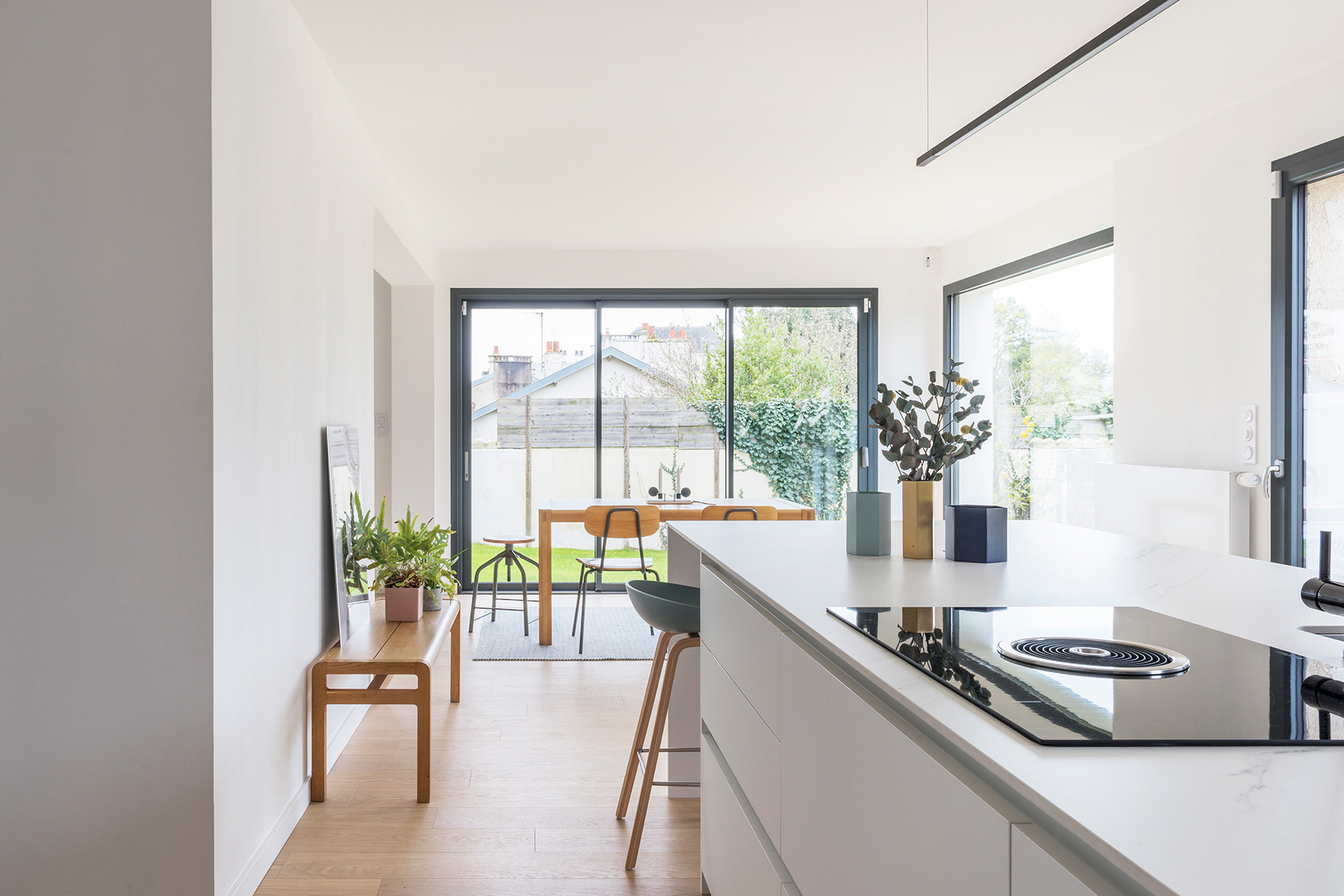 Agencement cuisine, salle à manger  et salon. Laque mate blanche, Façades de mobilier en Fenix bleu nuit. Parquet chêne naturel – Touche de Terrazzo. Emilie Guitton, architecte d'intérieur - Grand ouest, Nantes, Bretagne, Aquitaine, Pays Basque