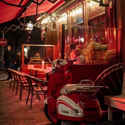 red scooter at night in front of cafe in Amsterdam
