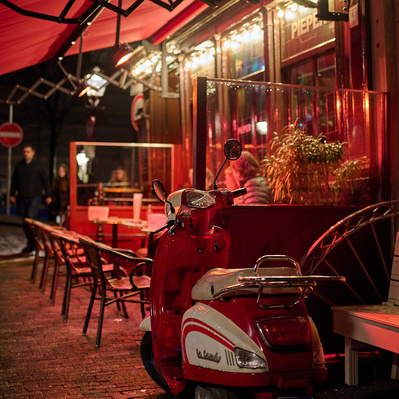 red scooter at night in front of cafe in Amsterdam

