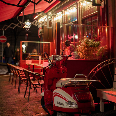 red scooter at night in front of cafe in Amsterdam

