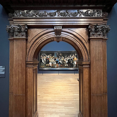 The night watch by Rembrandt through an arch in Rijsmuseum Amsterdam