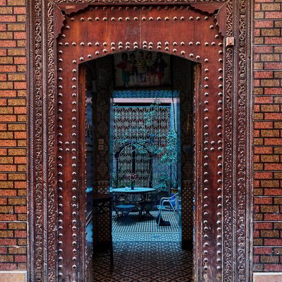 Moroccan landscape photograph featuring a beautifully carved and tiled entrance to a Riad in Marrakesh.