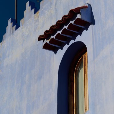 Chefchaouen window against blue wall.