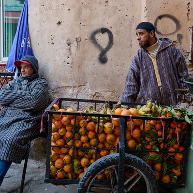 Moroccan  photograph featuring people selling fruit in the Souk marketplace in Fez. 