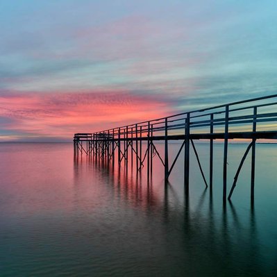 Sunrise over a hand-built pier over Lake Winnipeg, located in Donator, Manitoba.