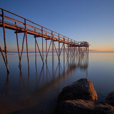 Sunrise over a hand-built pier over Lake Winnipeg, located in Donator, Manitoba.