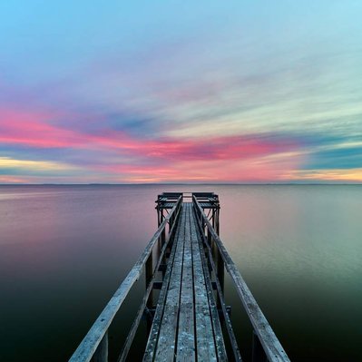 Sunrise over a hand-built pier over Lake Winnipeg, located in Donator, Manitoba. 