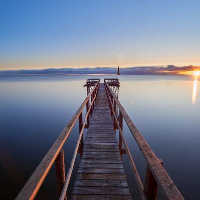 Sunrise over a hand-built pier over Lake Winnipeg, located in Donator, Manitoba.