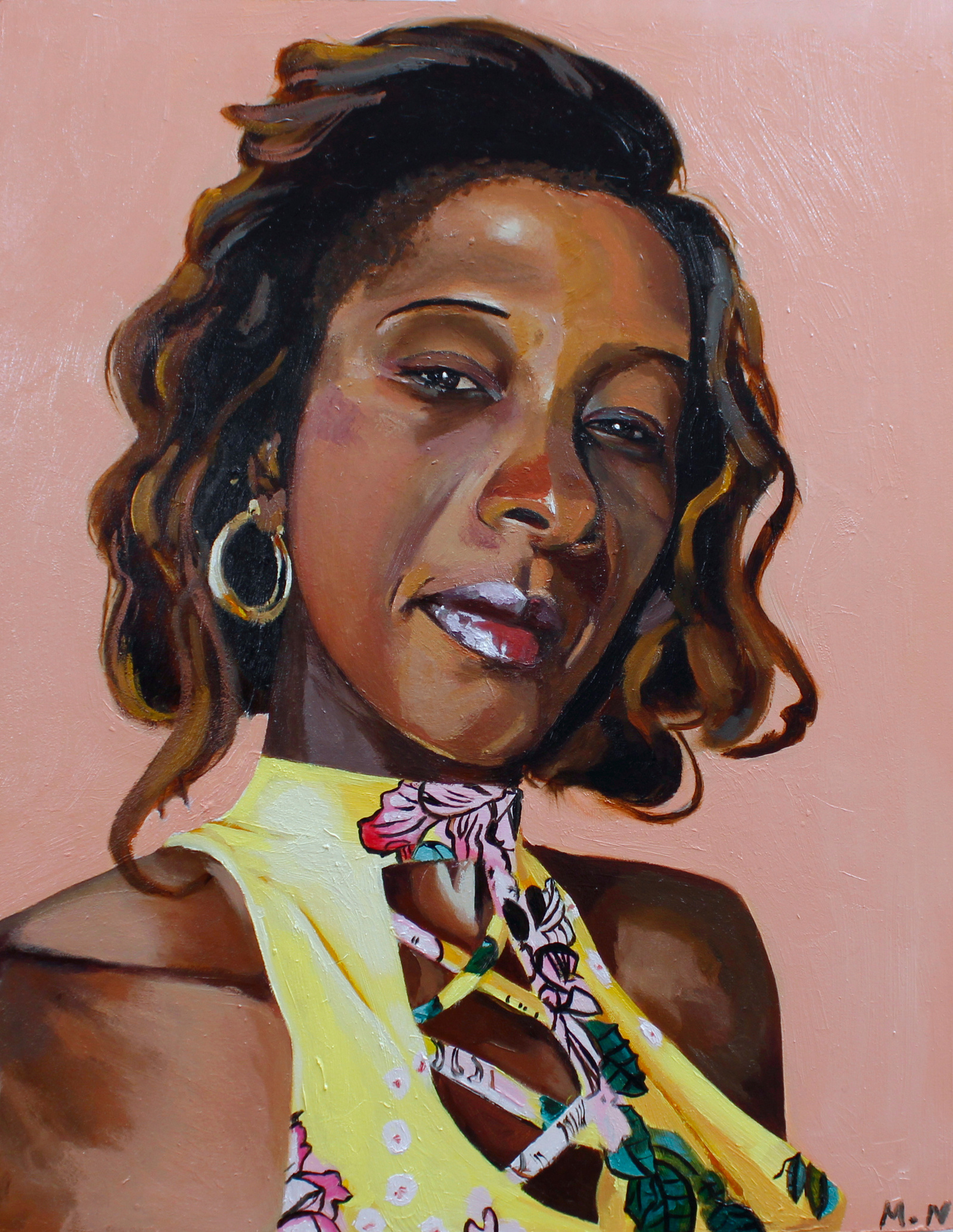 black woman looking directly at the camera in a yellow flowery top and gold hoop earrings