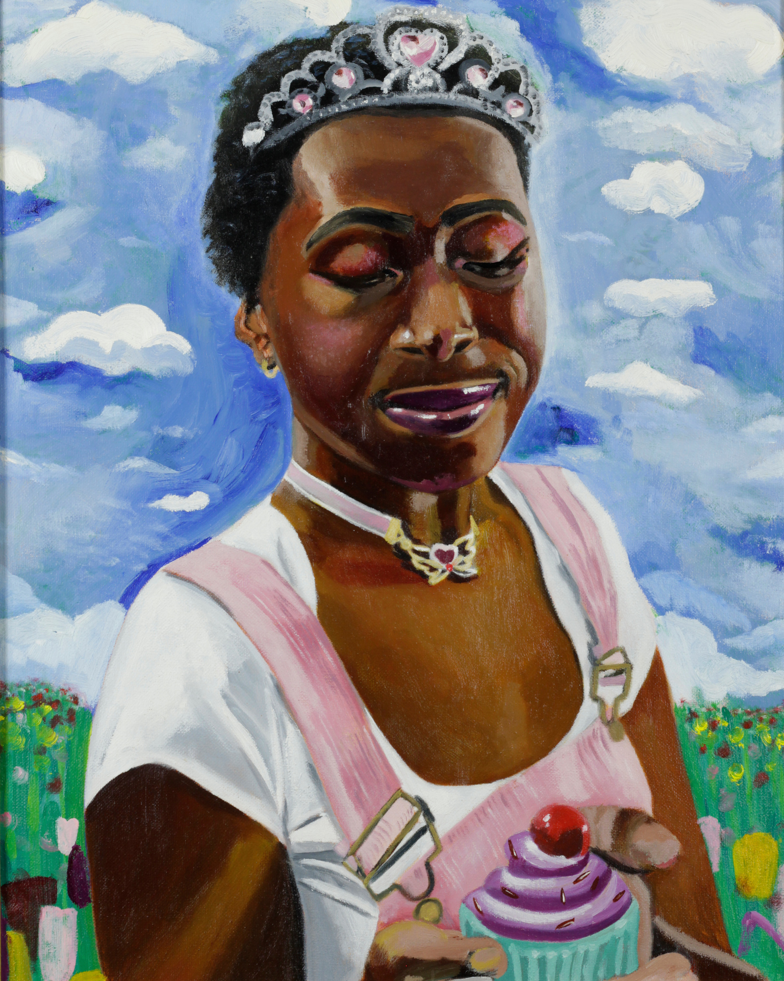 a black woman in a flowery field looking down at a cupcake happily while wearing a crown.