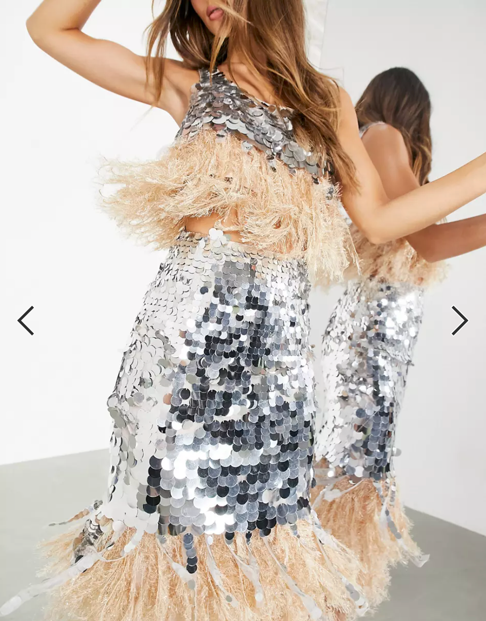 woman spinning in silver dress with feathers 