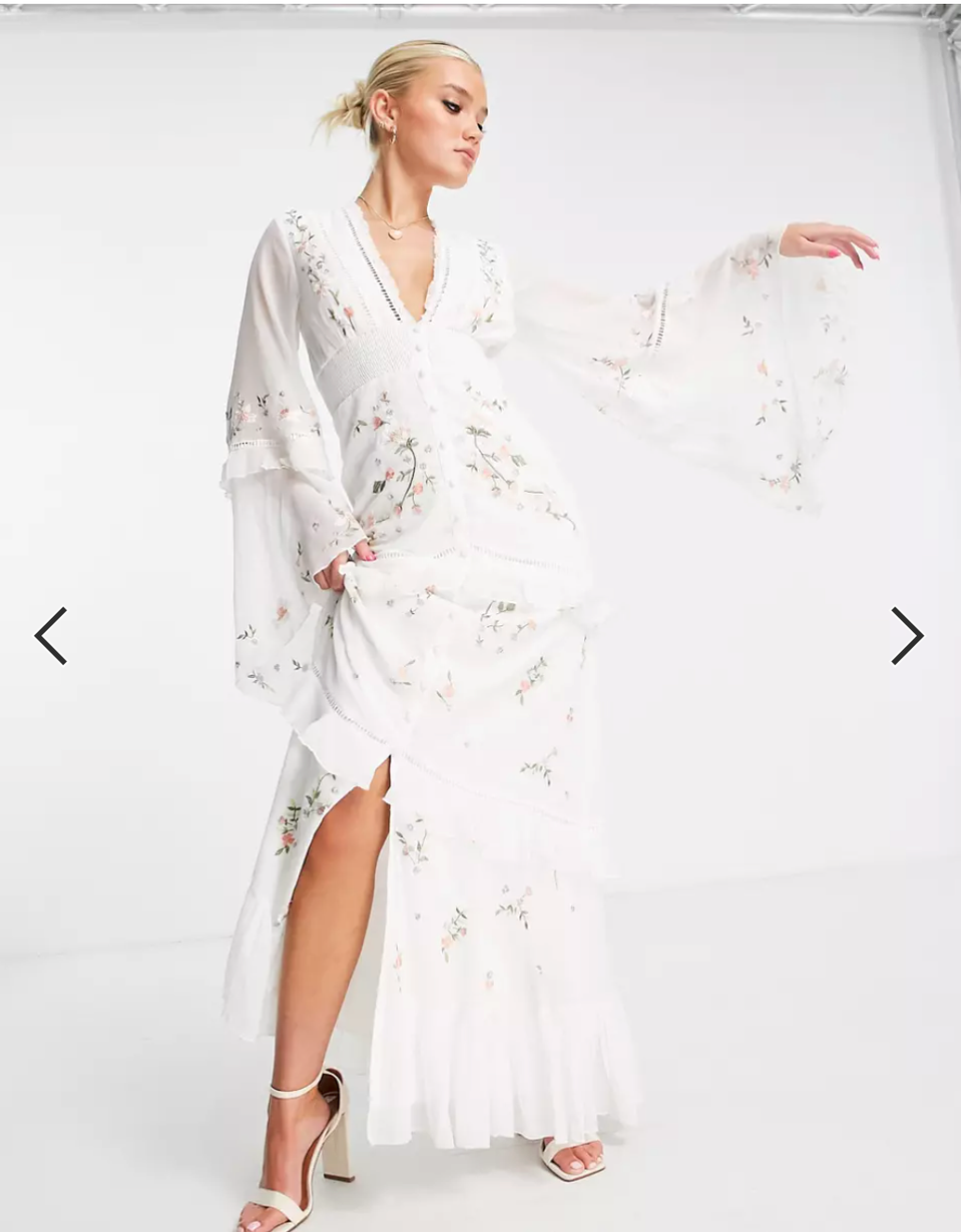 woman in white dress with arm up with a lace sleeve