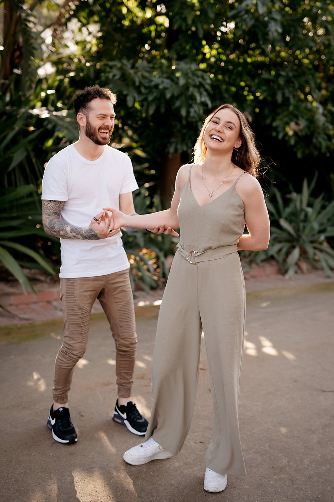 A couple laughing towards camera in a garden