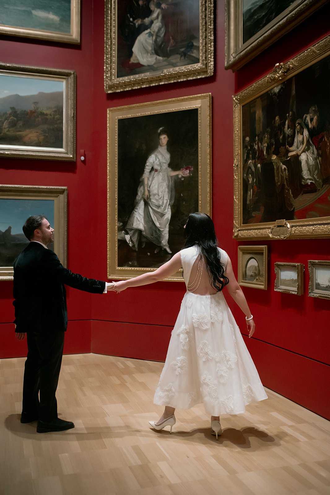 couple holding hands in art gallery
