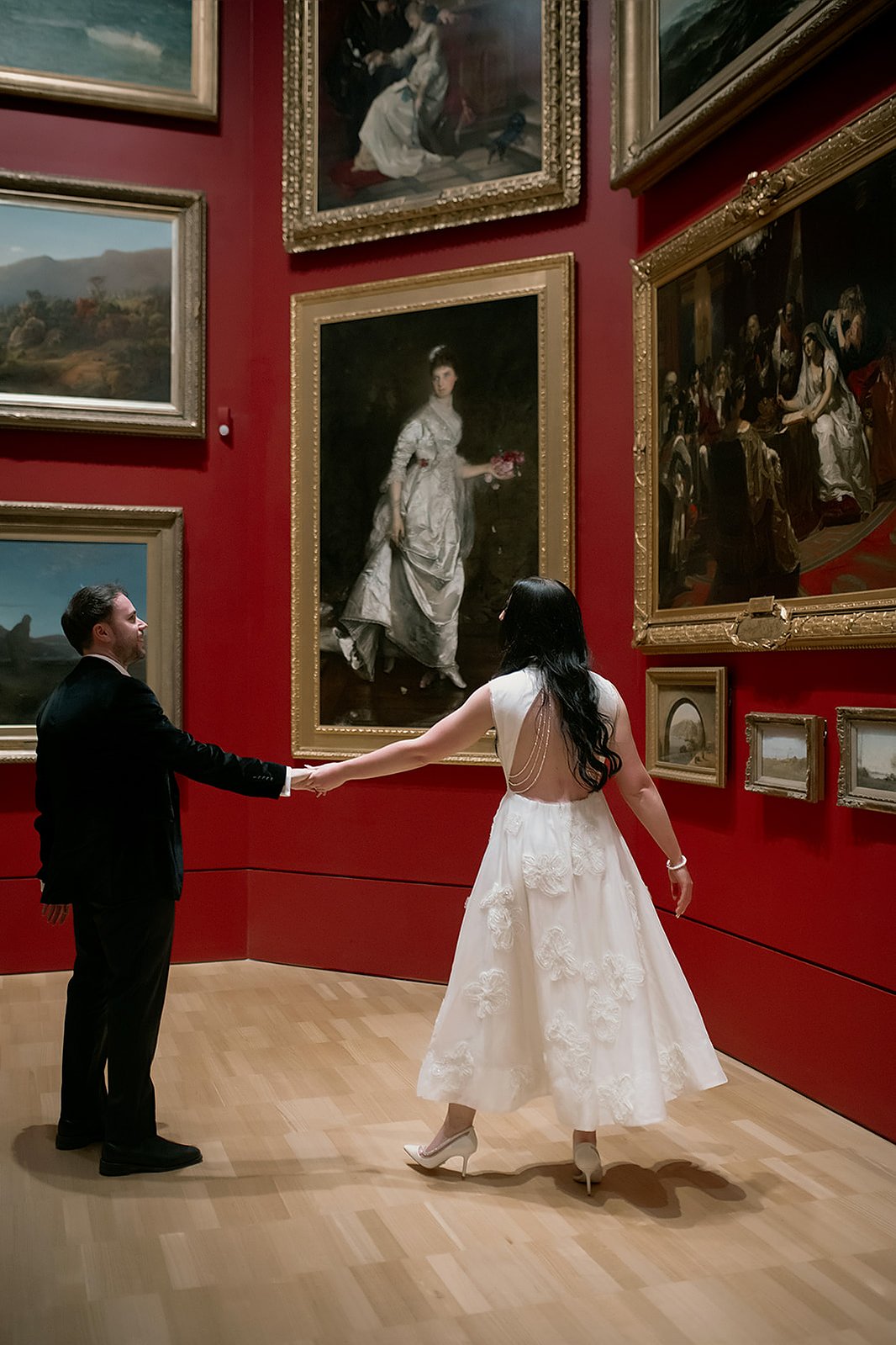 couple holding hands in art gallery