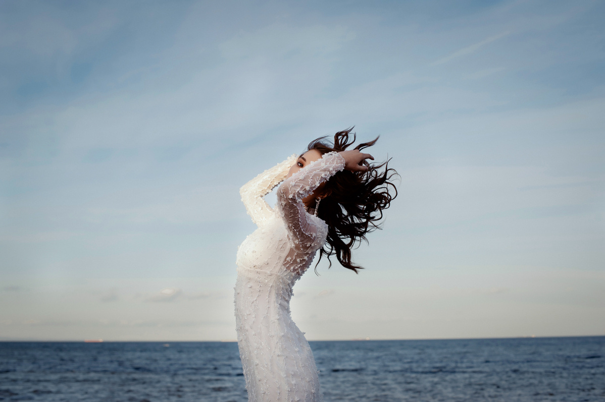 Bride flicking hair with the sea in the background
