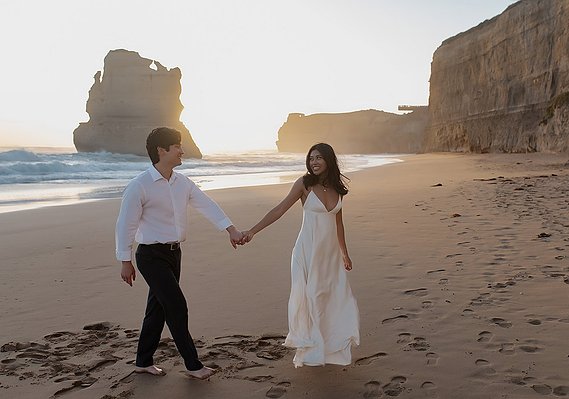 male and female holding hands on beach