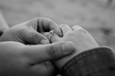 two hands close up displaying an engagement ring 