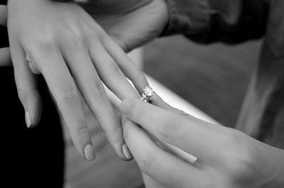 two hands close up displaying an engagement ring 