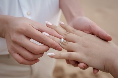 two hands close up displaying an engagement ring 