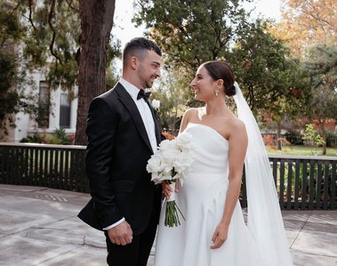 Newly Weds looking at each other with garden in background.  
